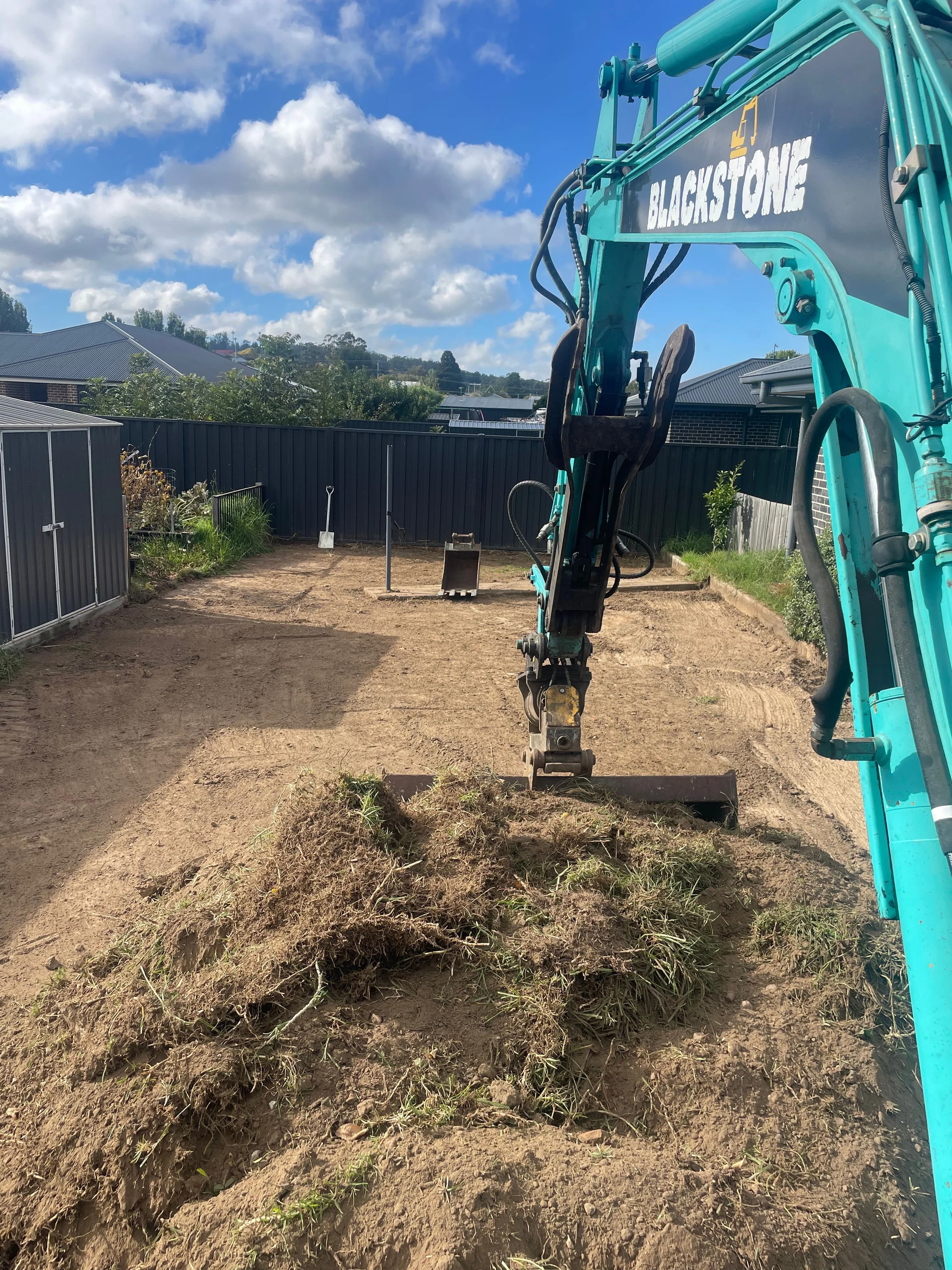 Blackstone Excavations excavator clearing a backyard site