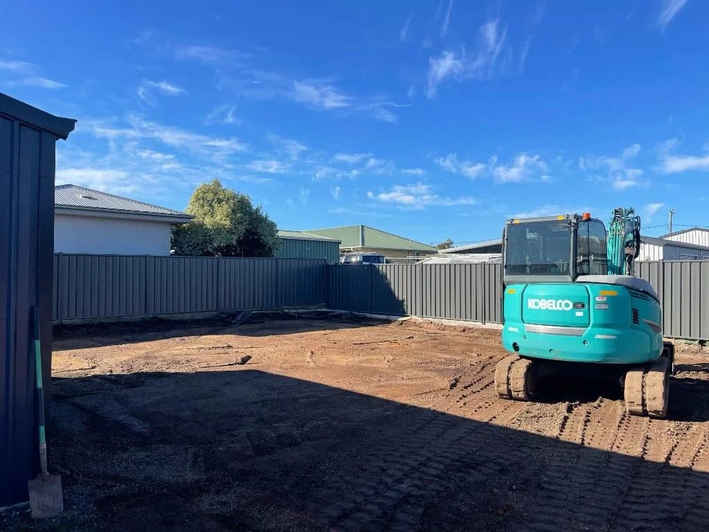 Kobelco excavator on cleared backyard site ready for landscaping